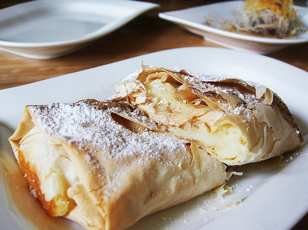 Bitar av bougatsa med frasig filodeg och krämfyllning på ett fat