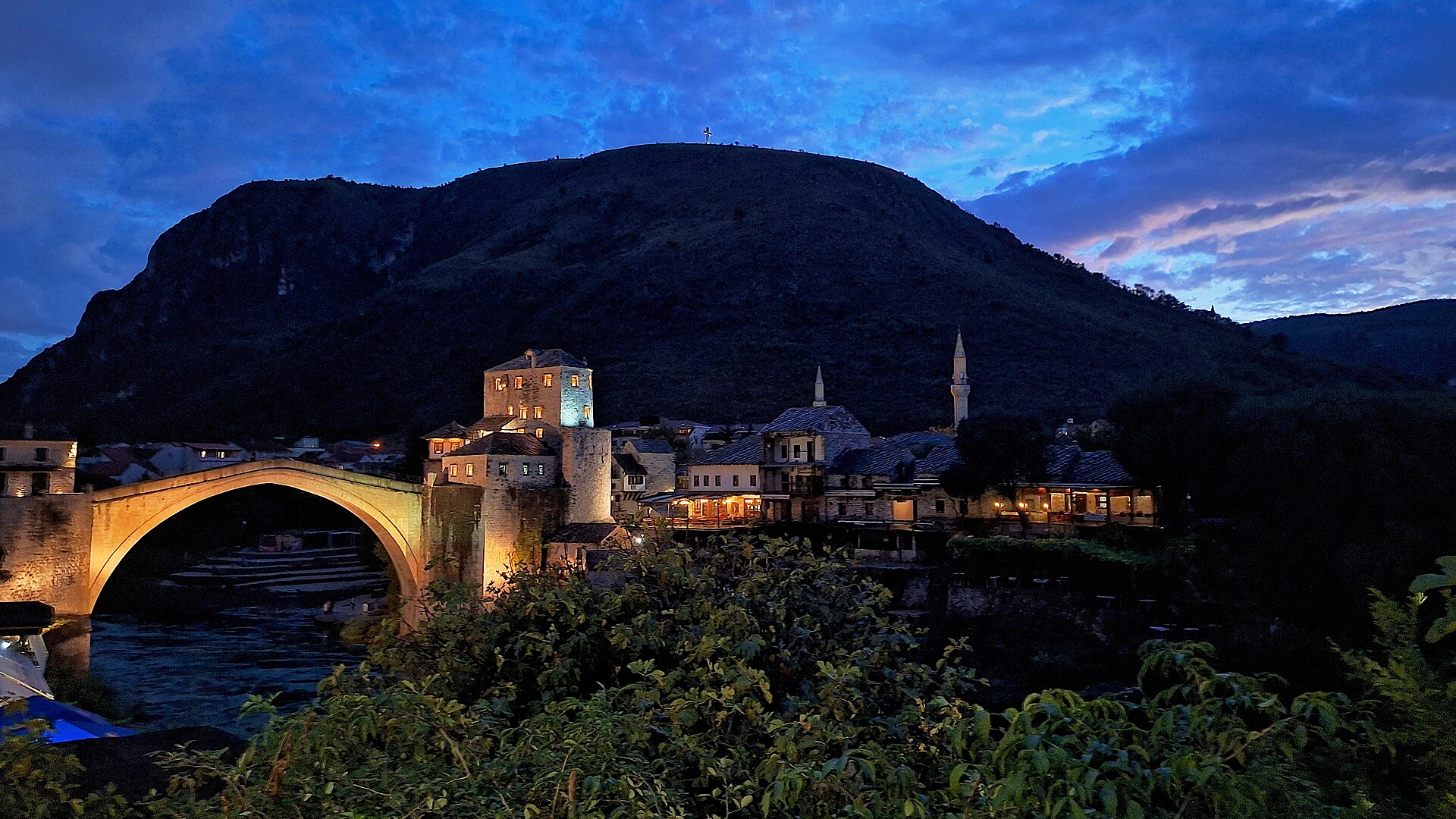 Den historiska osmanska stenbron Stari Most i Mostar sträcker sig över det smaragdgröna vattnet i floden Neretva.