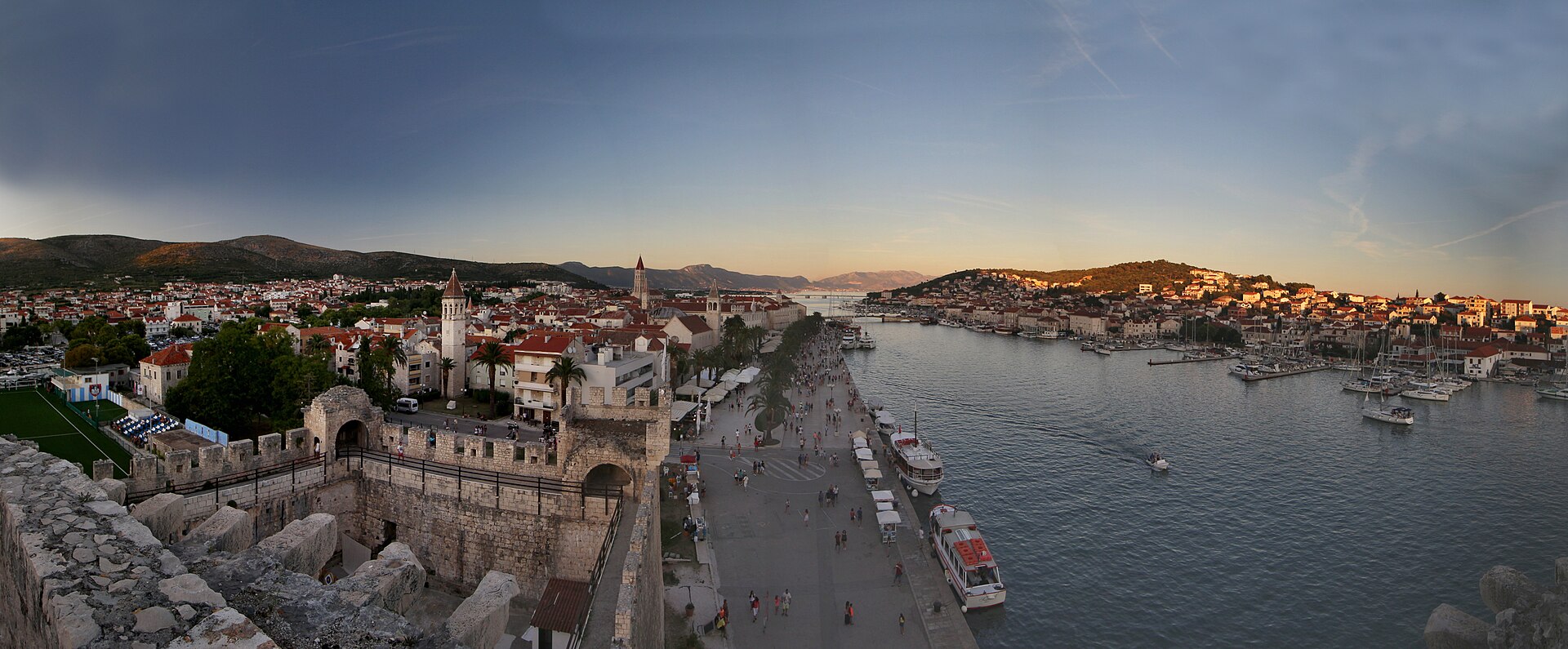 Panoramavy över Trogirs historiska gamla stan i Kroatien, med sina karaktäristiska röda tak, omgiven av adriatiska havet.
