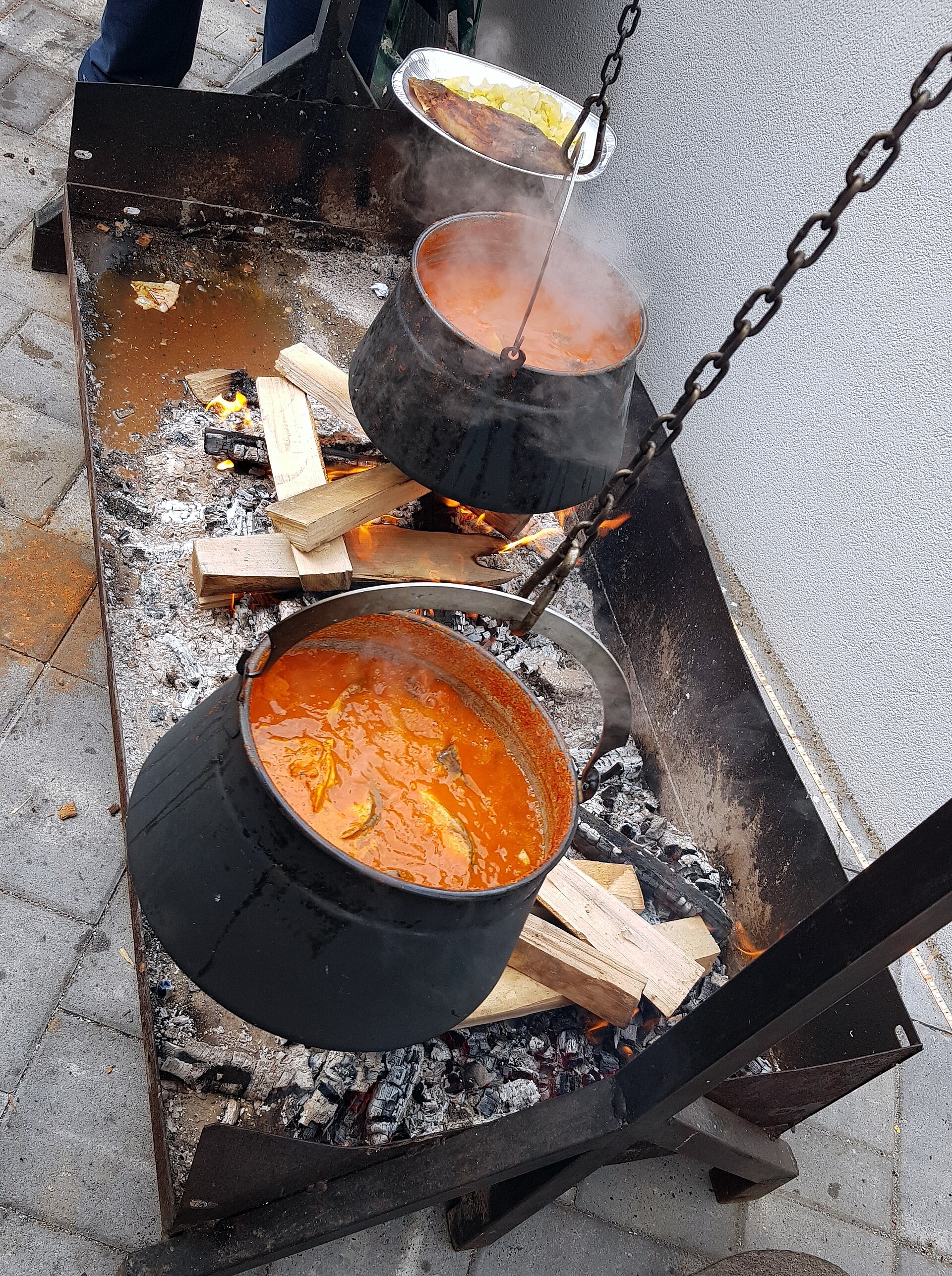 Traditionell fiš paprikaš som sjuder i en kopparkittel över en öppen eld i Baranja.