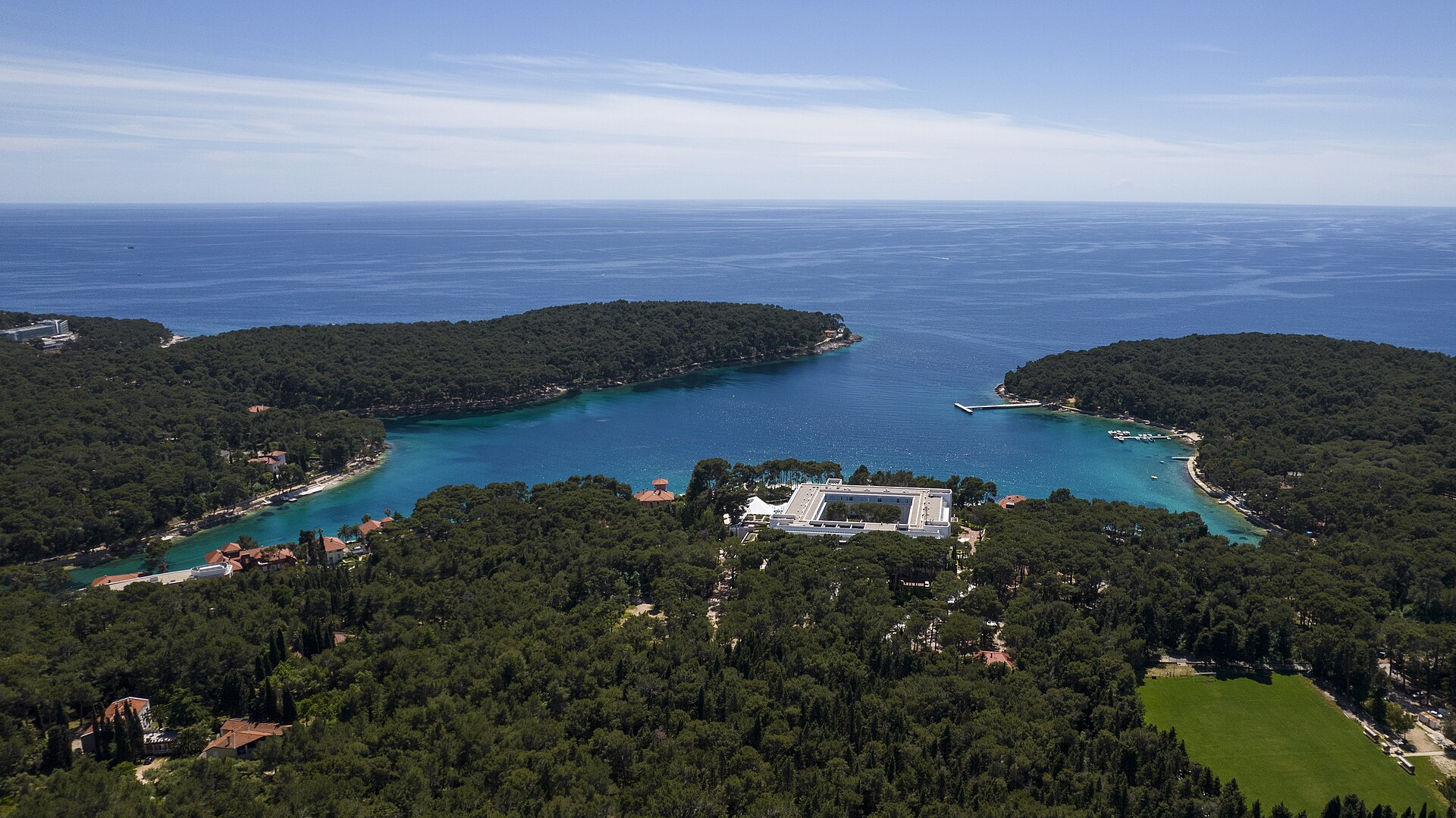 Čikat-viken vid Mali Lošinj med tallskog som växer ända ut mot det klara vattnet.