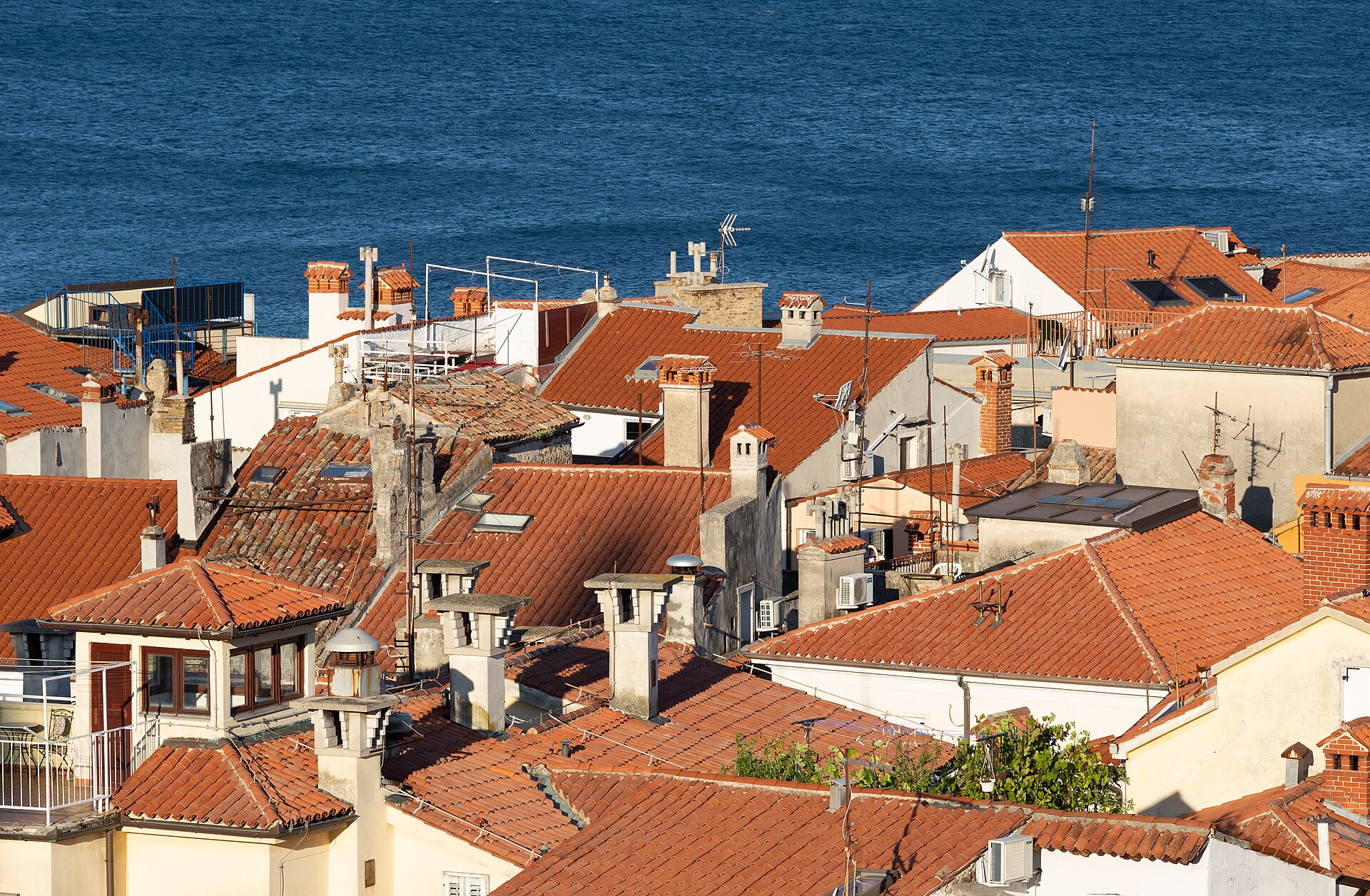Vy över den slovenska kuststaden Piran med sina röda tak och det turkosblå Adriatiska havet.