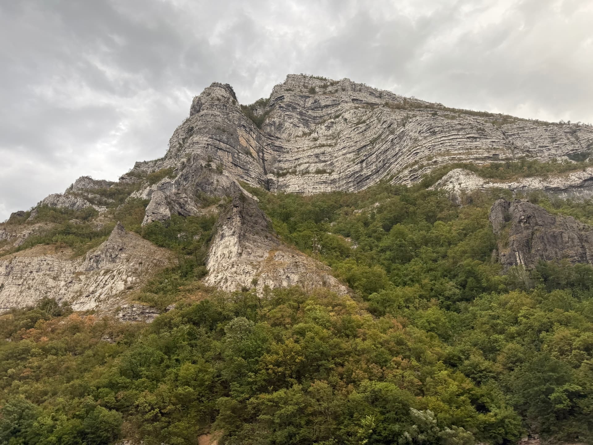 En dramatisk bergvägg med tydliga geologiska lager längs vägen söderut.