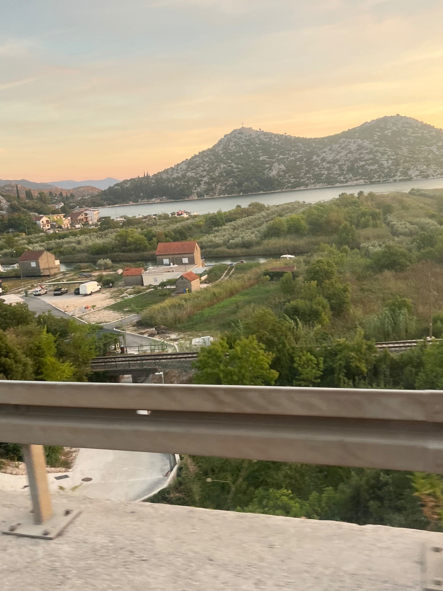 Vatten, berg och grönska i kvällsljus söderut längs Neretva.