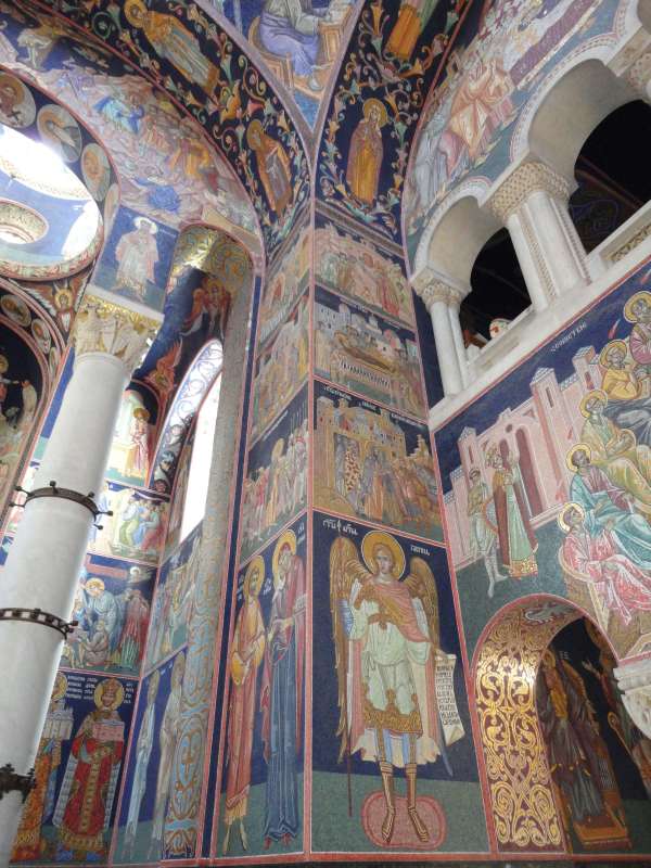 Väggar, pelare och valv täckta av färgstarka mosaiker med helgon och bibliska scener i Sankt Georgs kyrka.